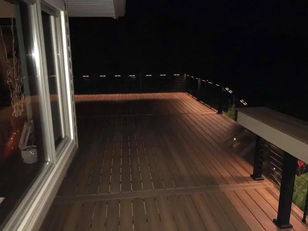 Night view of a deck with built-in lights along the steps and handrails.