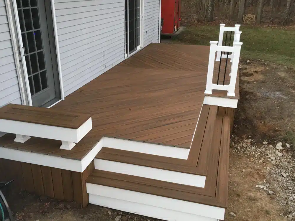 White deck stairs leading to a red door, adjacent to a white railing photo - Hen House Decks