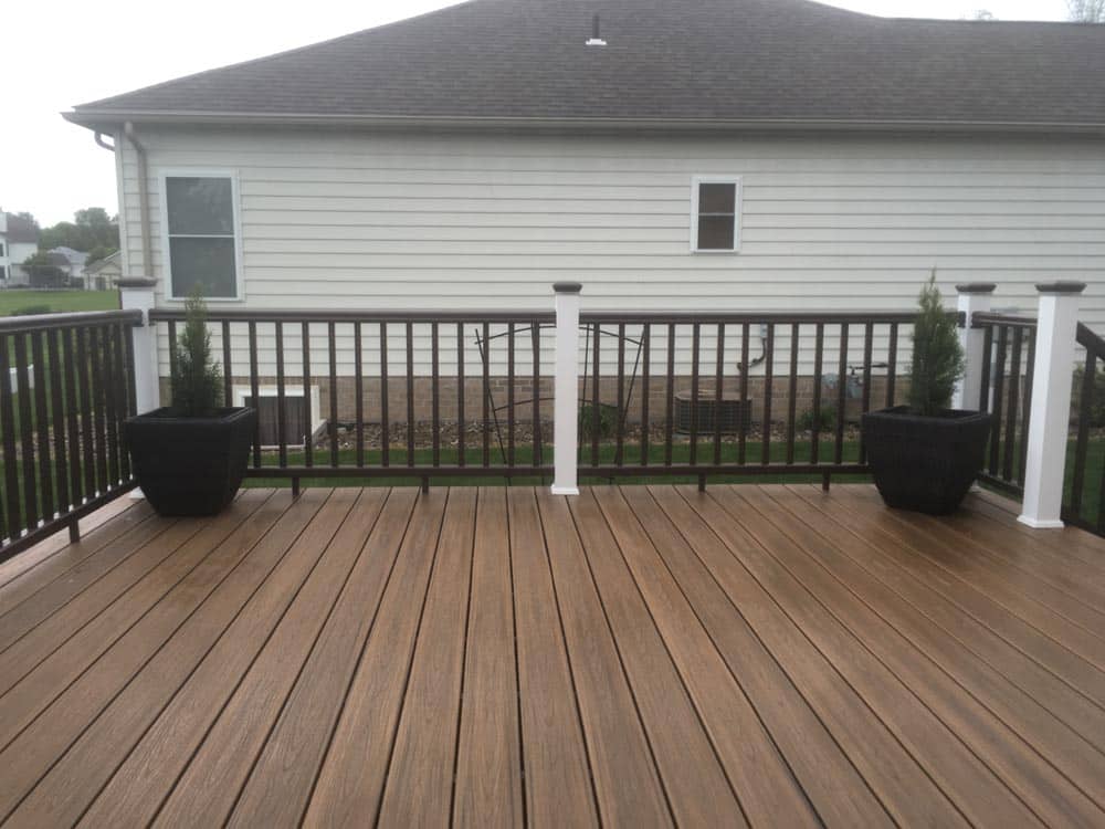 Wide wooden deck with no railing, attached to a house.