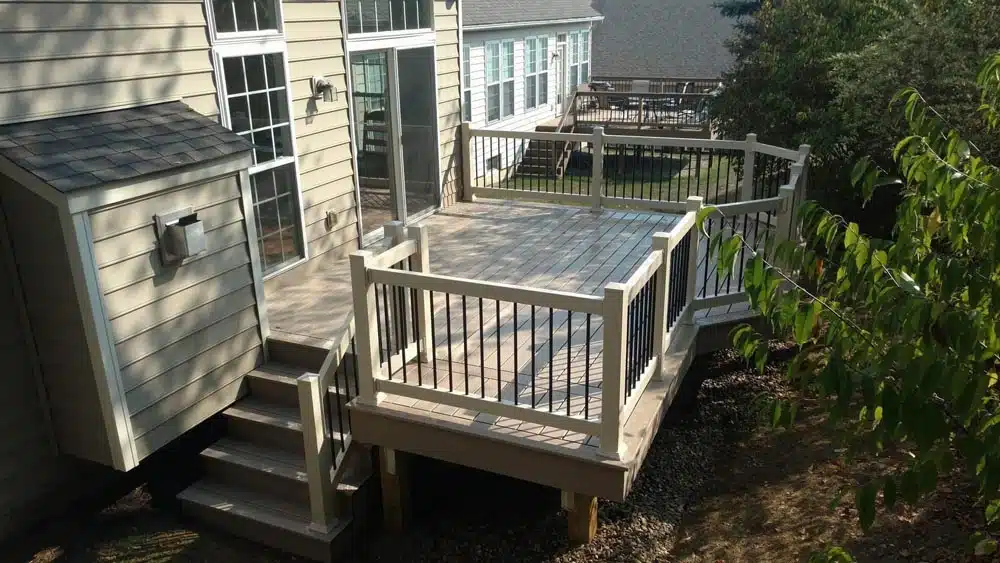 Aerial view of a wooden deck with dark railings and a spiral staircase.