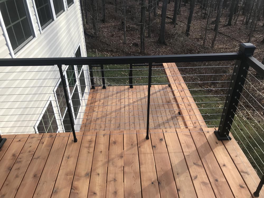 Multi-level deck with white railings attached to a house.