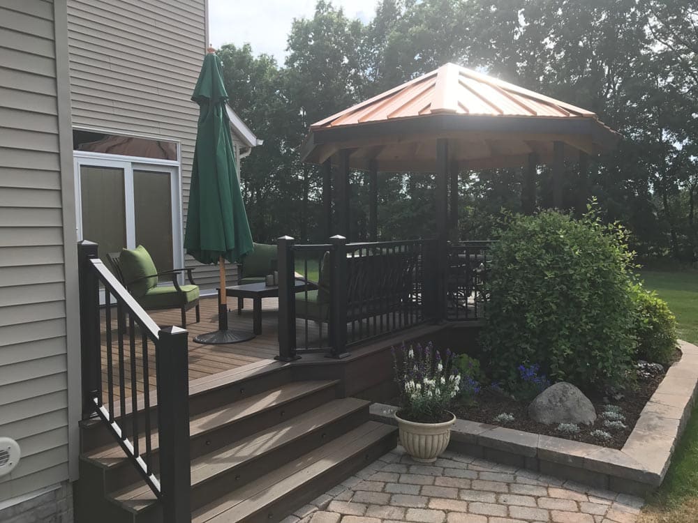 Wooden deck with railing and a gazebo covering a patio furniture set
