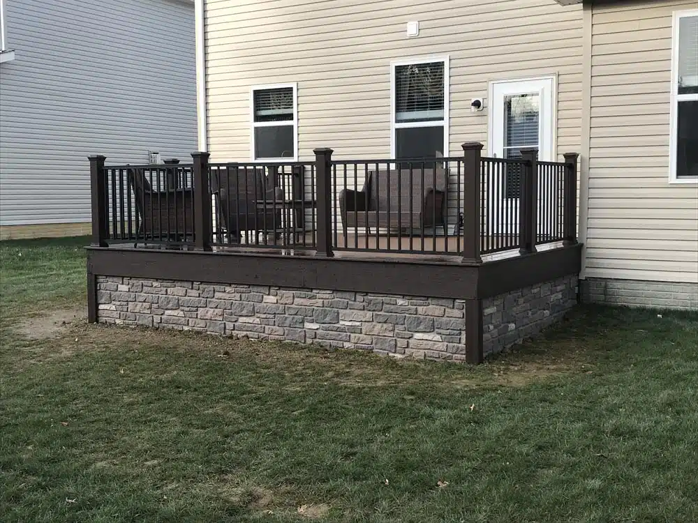 Spacious deck overlooking a lawn, with a black railing and built-in lighting on the posts