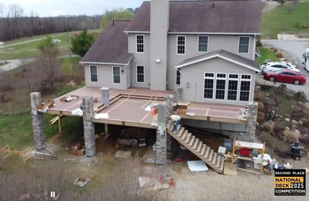 Home 7 Elevated deck under construction on a two-story home with stone support columns, framed decking boards and exterior staircase — Do I Need a Permit to Build a Deck in Ohio
