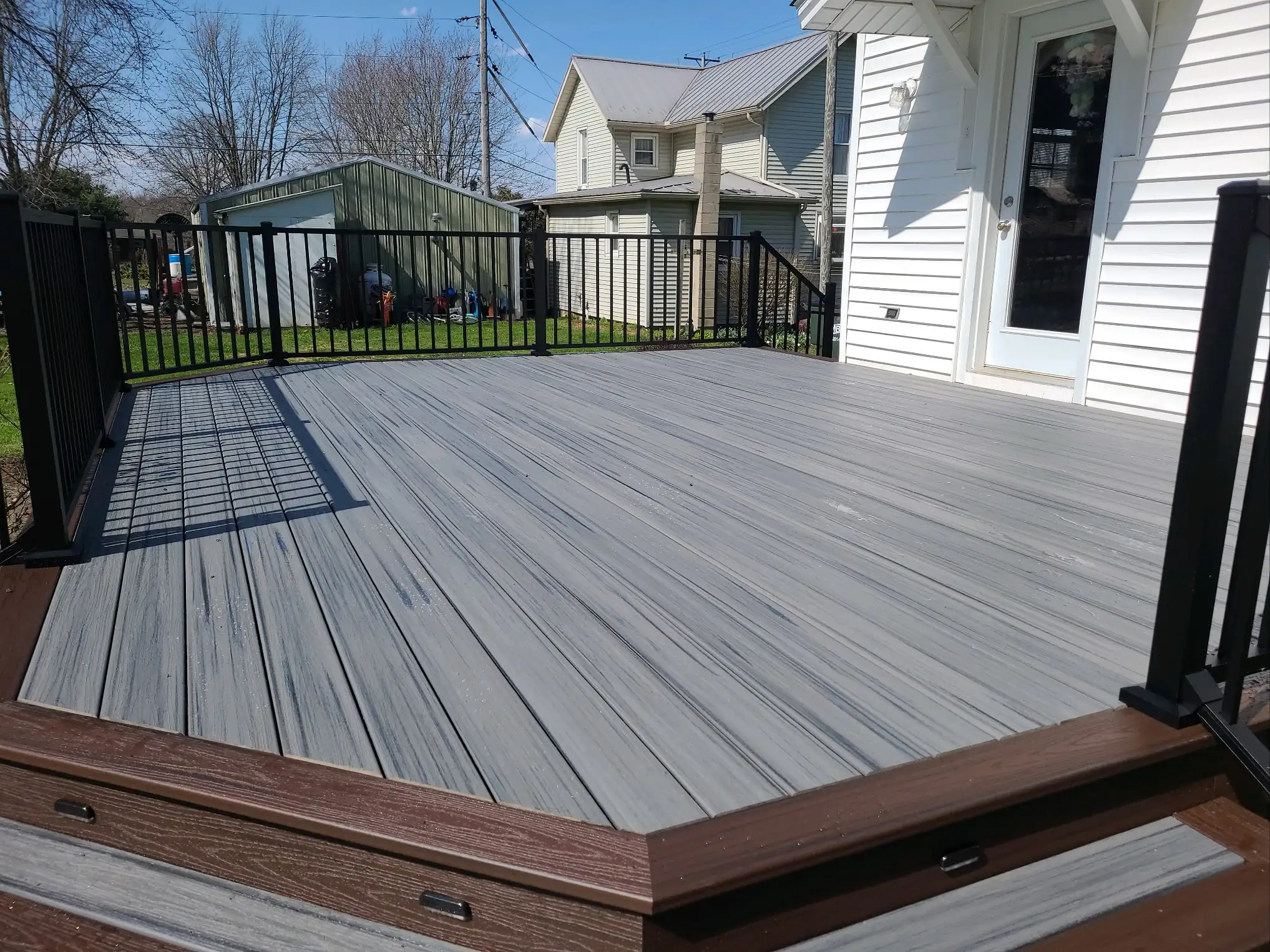 Deck Resurfacing Cost in Ohio Gray Composite Deck with Black Metal Railings — Fresh gray composite decking with textured wood-grain boards and black metal safety railing